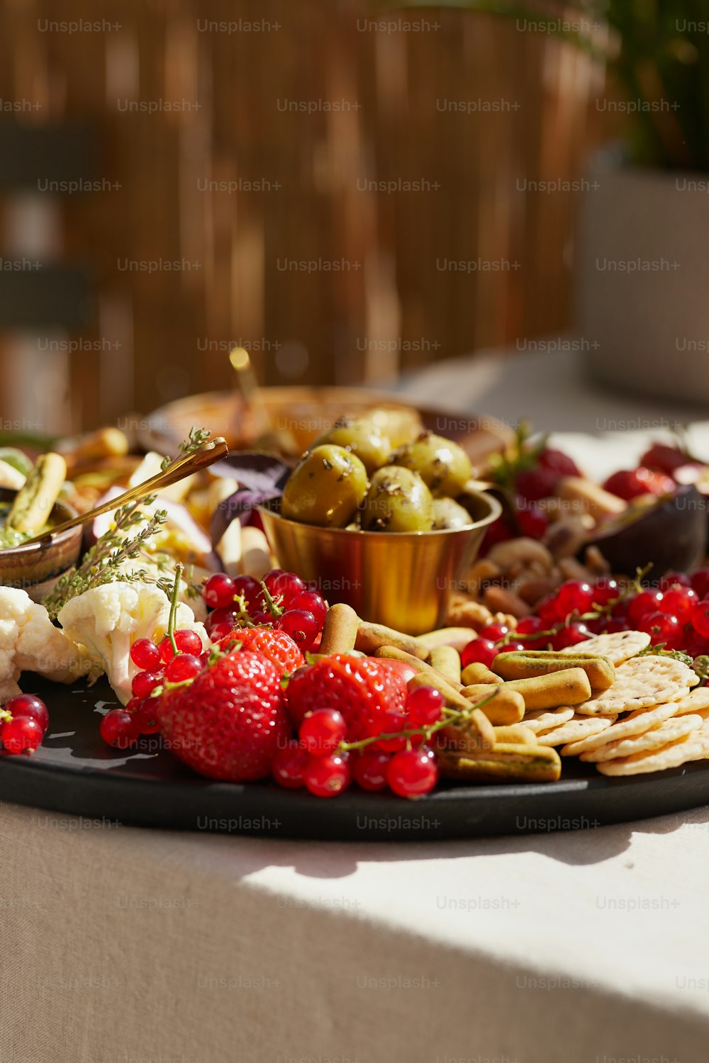 eine Platte mit Obst und Crackern auf einem Tisch