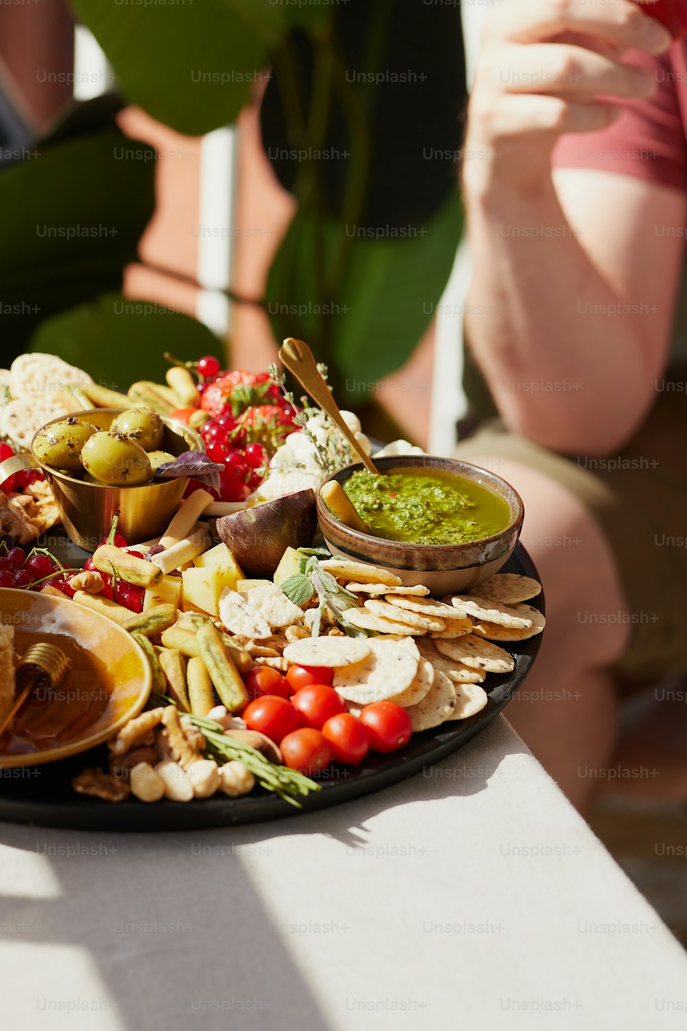 a platter of food on a table with a woman taking a picture of it