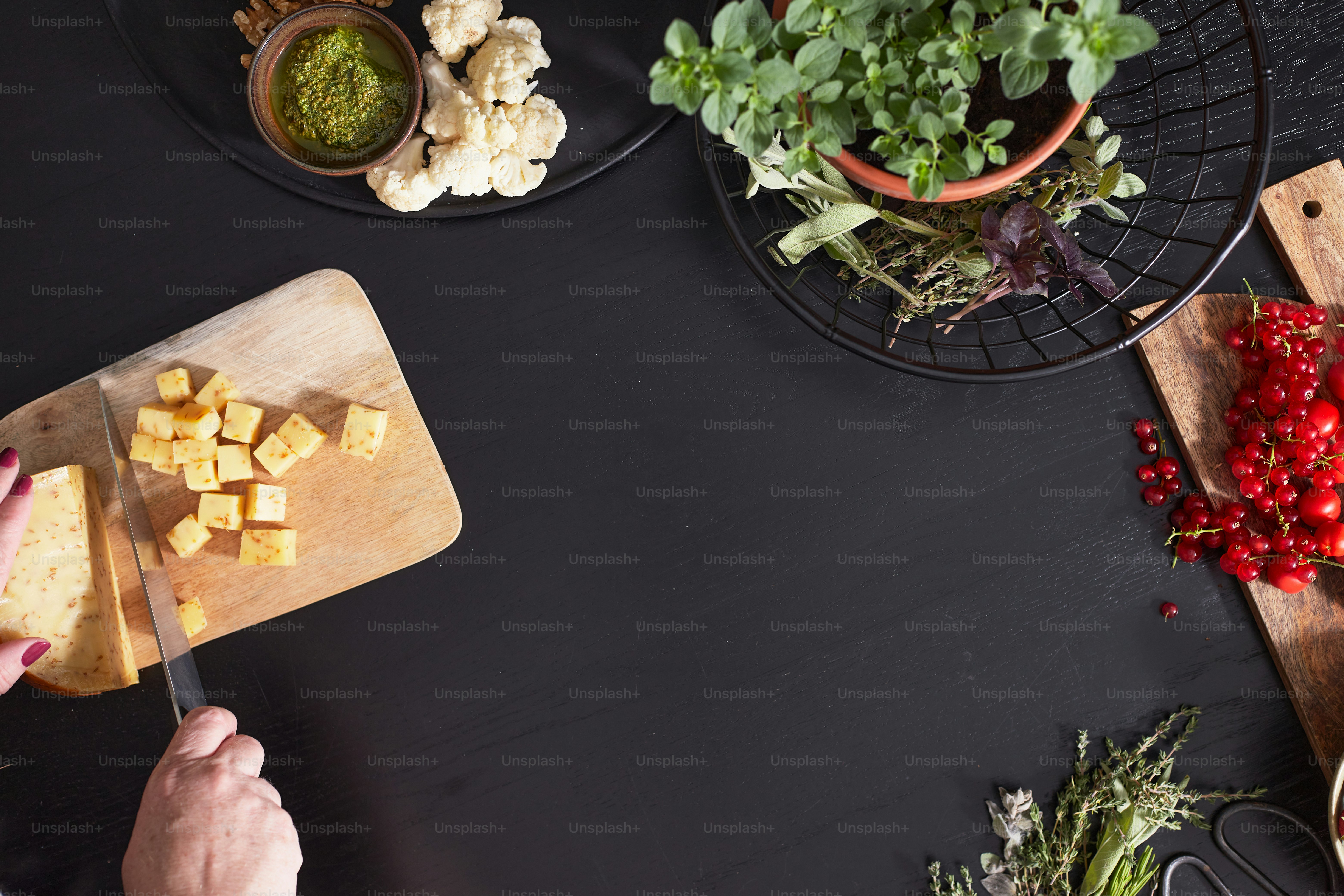 Preparing a charcuterie board on a black wooden surface