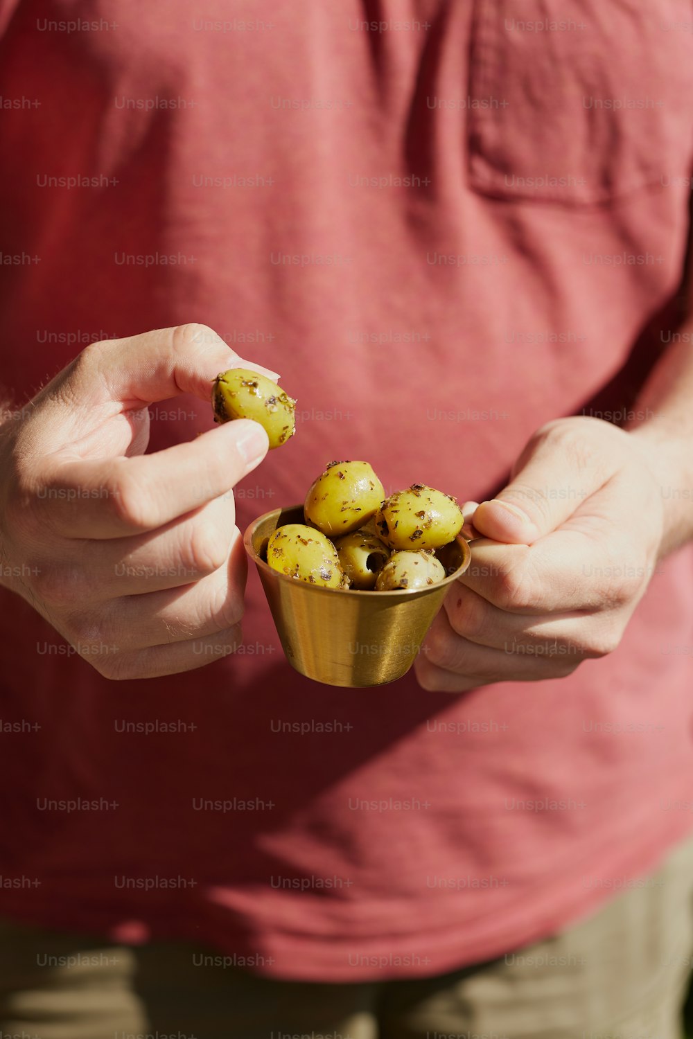 a man holding a cup filled with potatoes