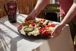 a plate of food on a table with a person reaching for it