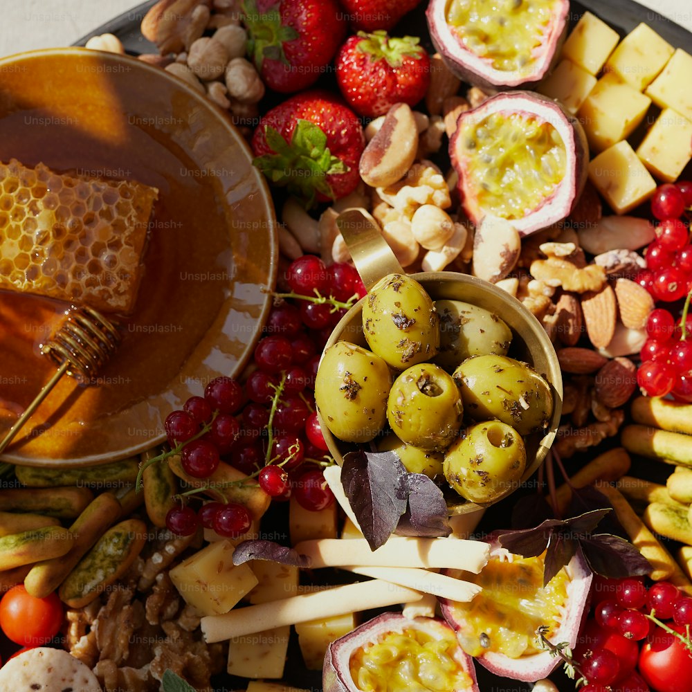 a platter of fruit and nuts with a honey dip