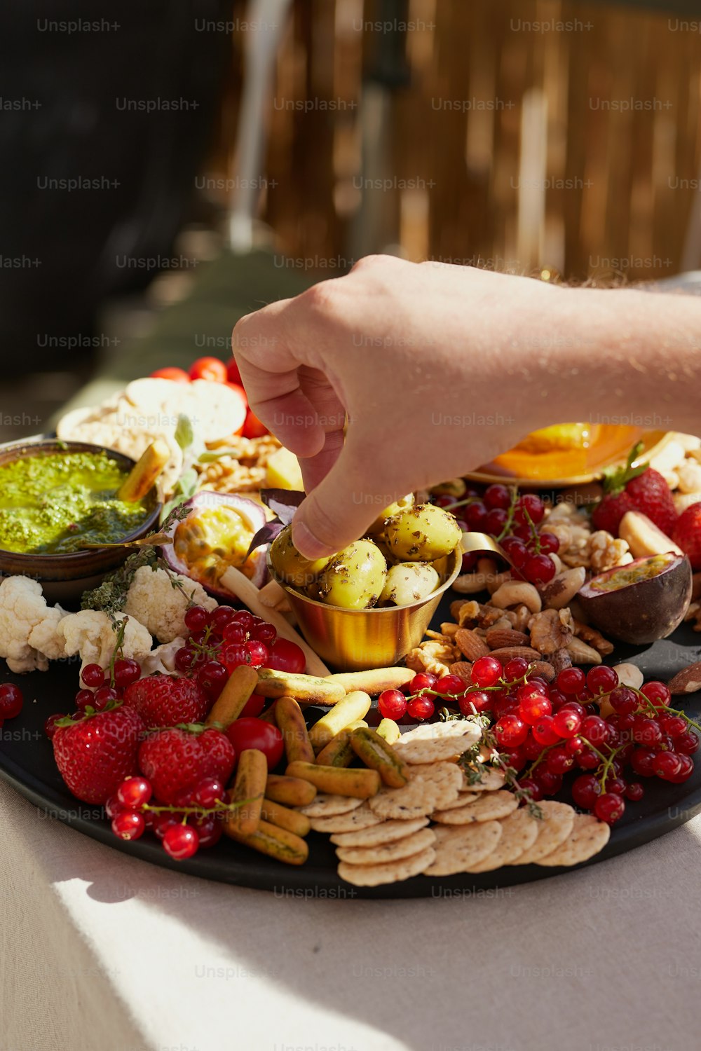 a plate of food that includes crackers, fruit, and nuts