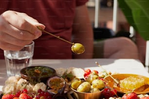 a person holding a stick over a plate of food