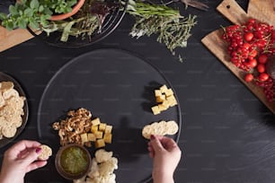 a black plate topped with crackers and vegetables