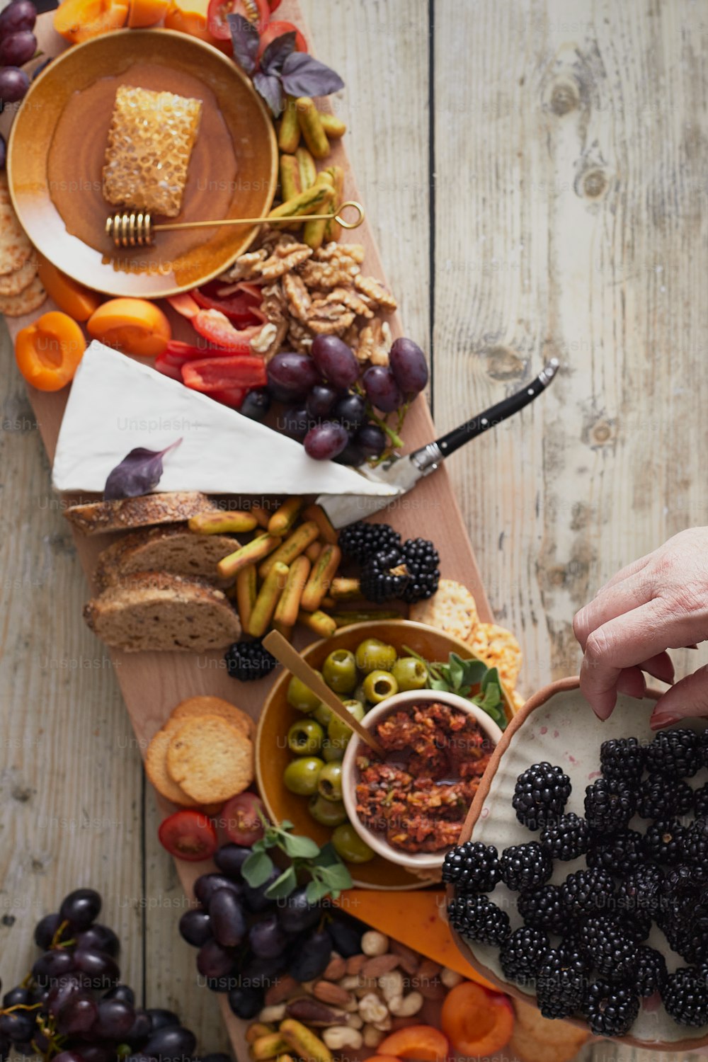 a platter of fruit, bread, and crackers on a wooden table