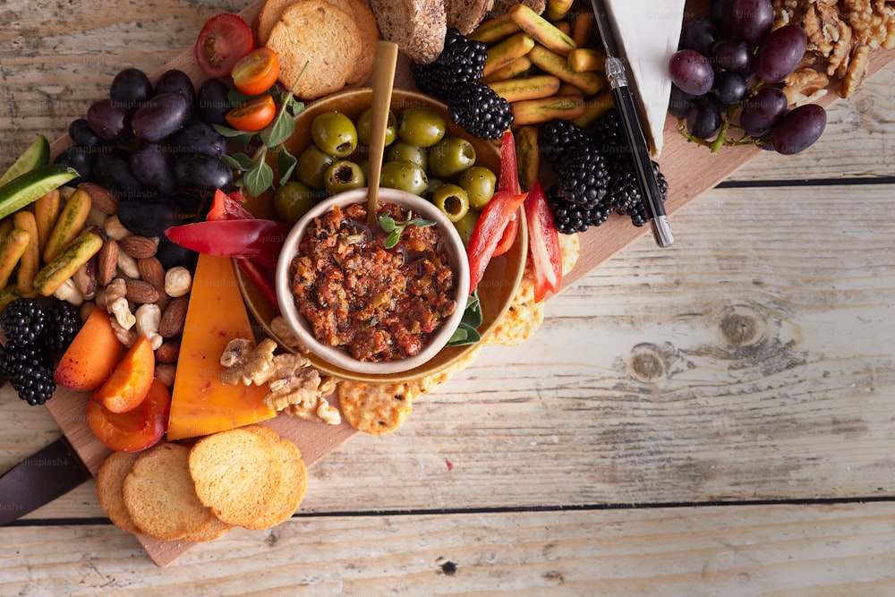 a platter of fruit, nuts, crackers, and crackers