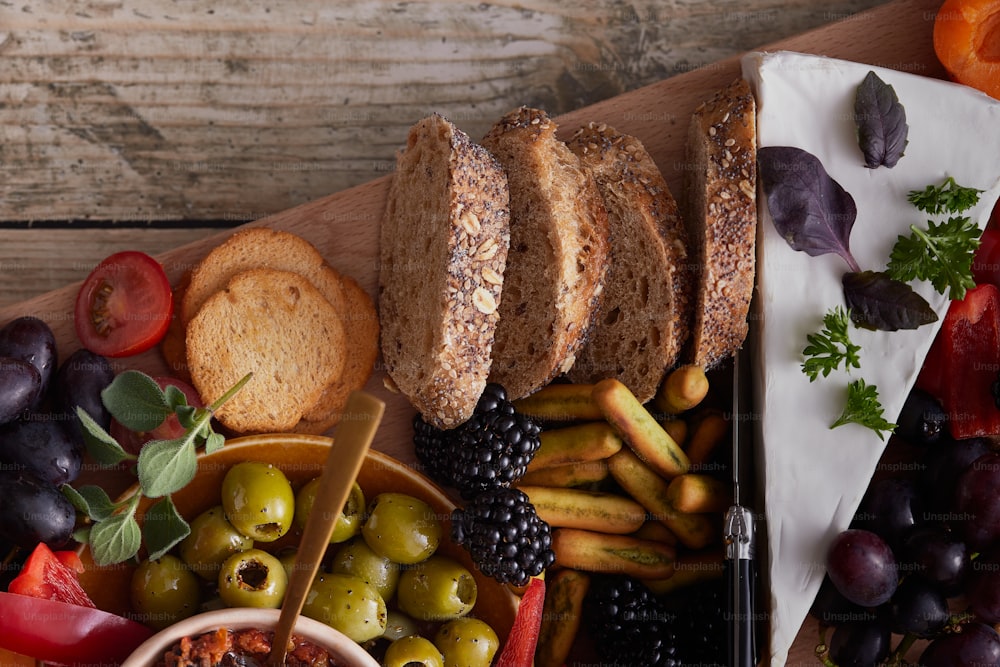 eine Platte mit Brot, Oliven, Brot und Obst