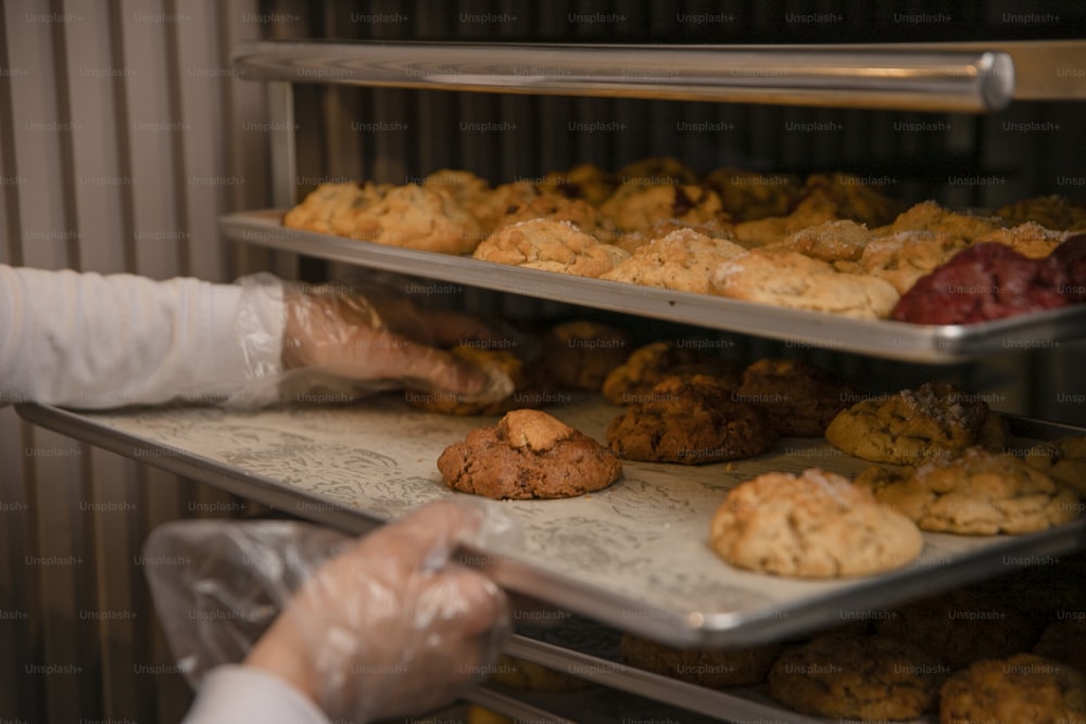 a person reaching for a tray of cookies
