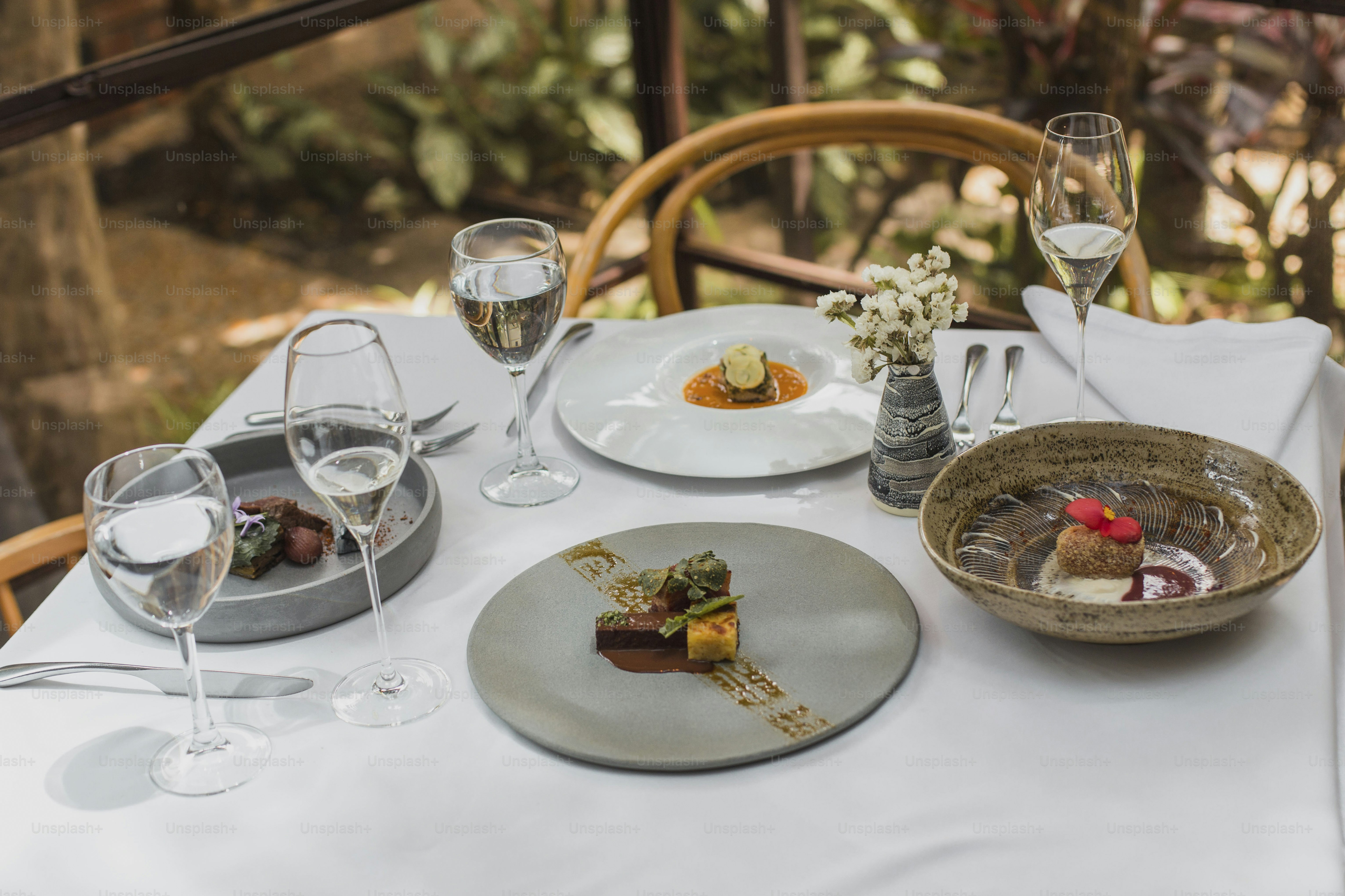 a table topped with plates of food and glasses of wine