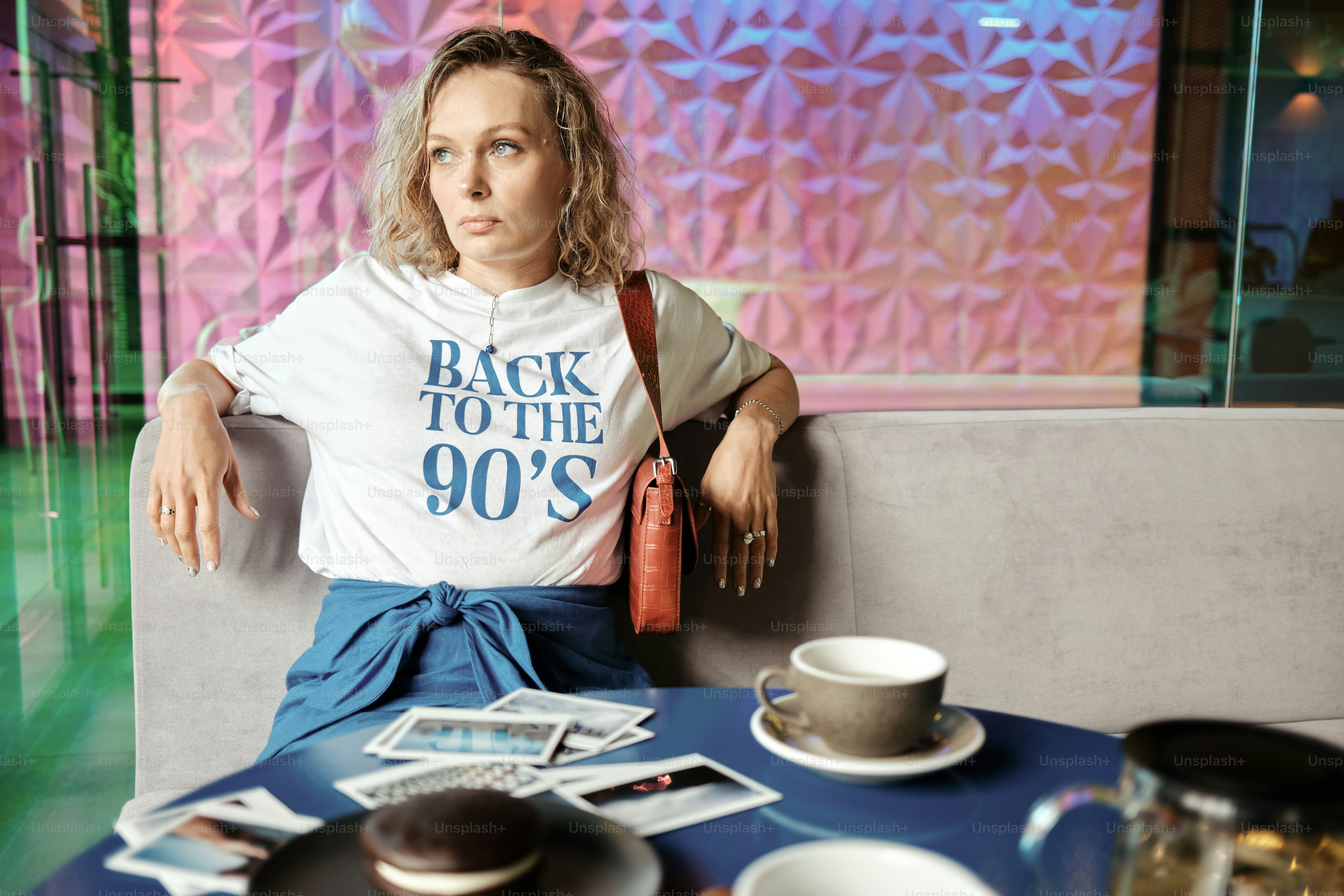 a woman sitting at a table with a cup of coffee