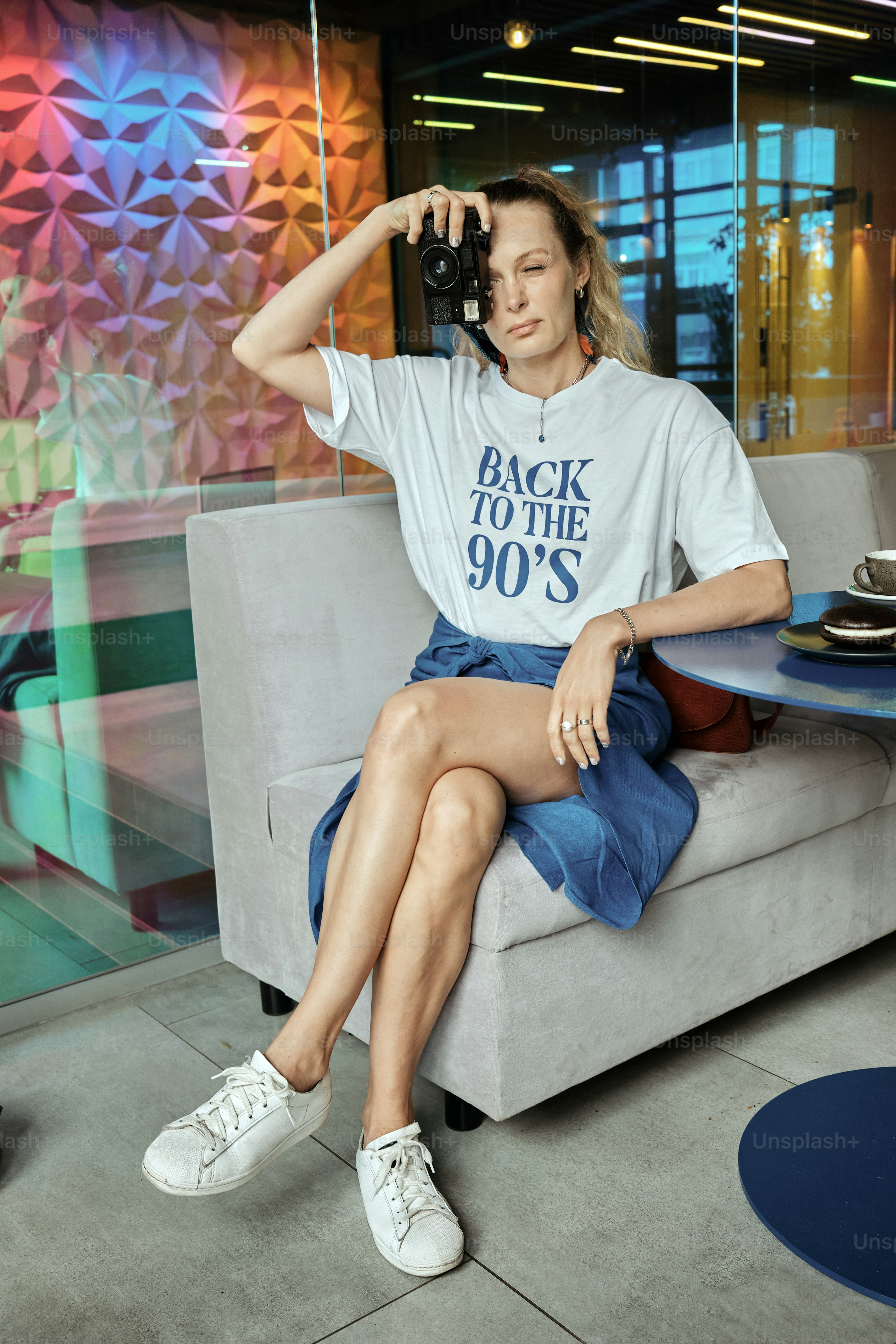 a woman sitting on a couch holding a camera