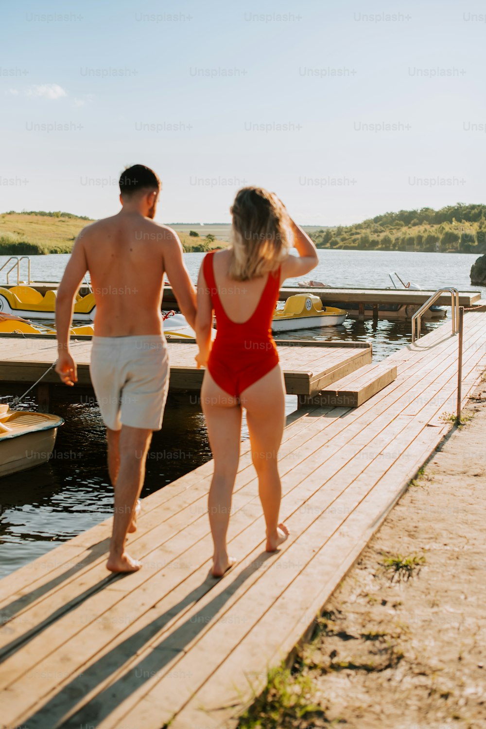 a man and a woman walking on a dock