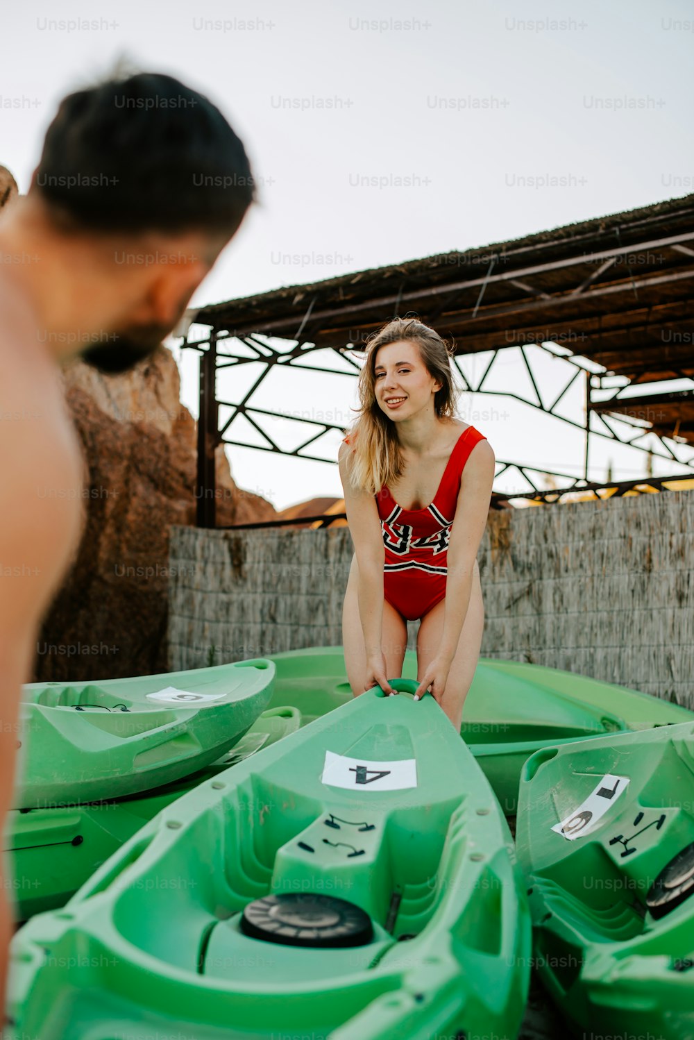 a woman in a bathing suit sitting on a green boat