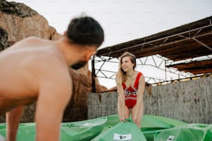 a woman in a bathing suit standing next to a man in a red bathing suit