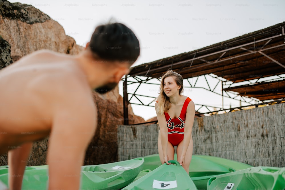 a woman in a bathing suit standing next to a man in a red bathing suit