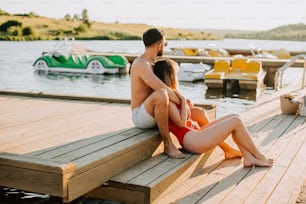 a man and a woman are sitting on a dock