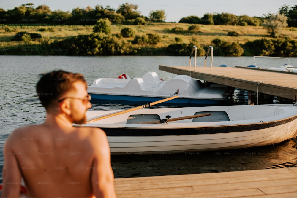 Un uomo in piedi su un molo accanto a una barca