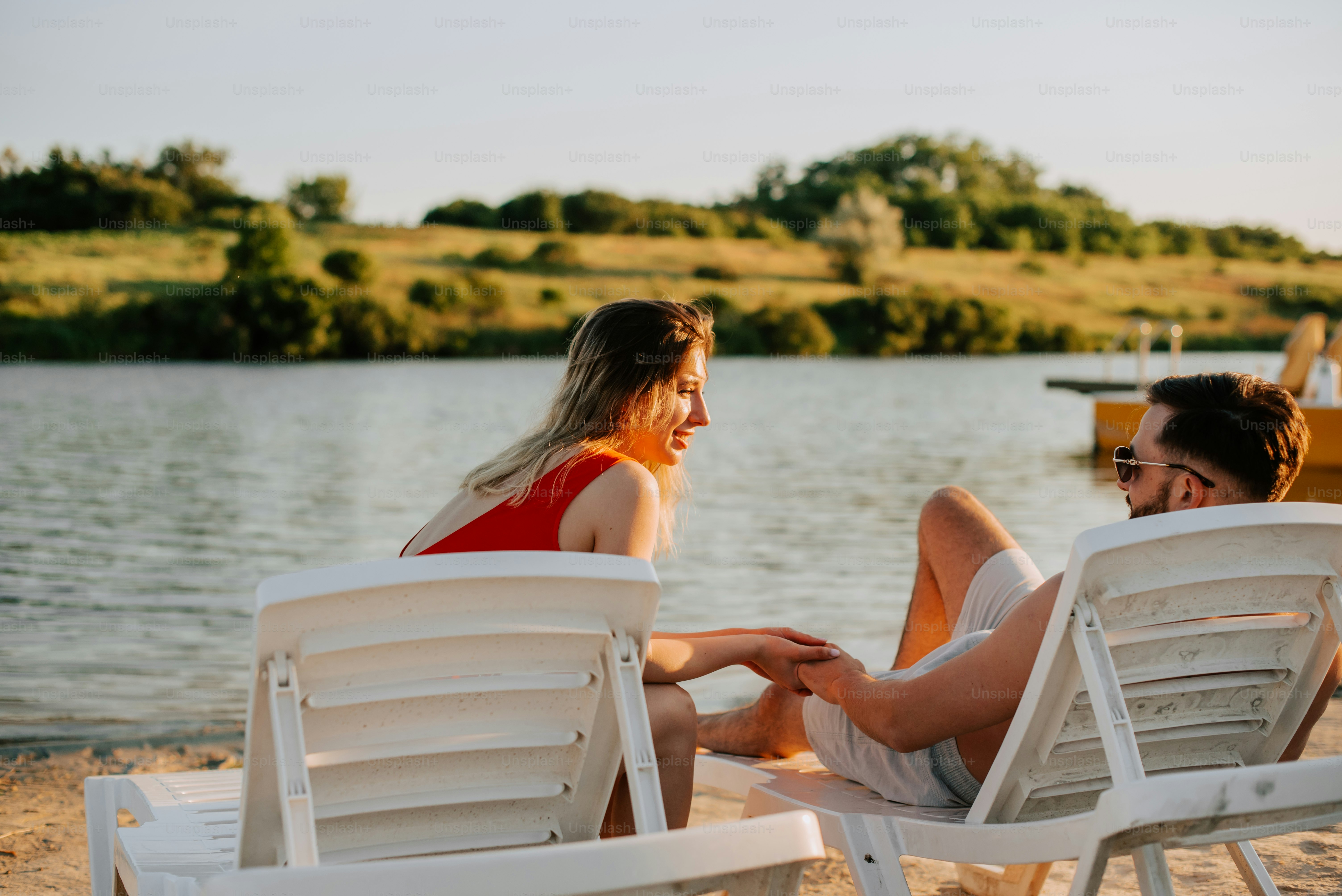 a man and a woman sitting on beach chairs