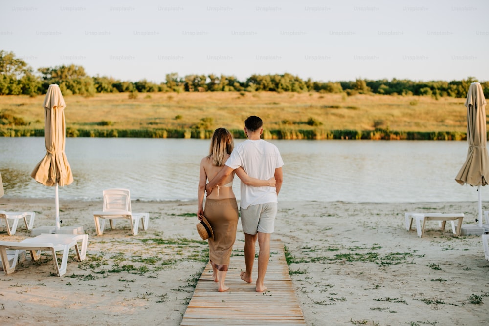 a man and a woman walking down a wooden walkway