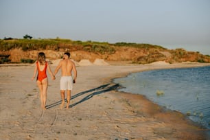 a man and a woman walking on the beach