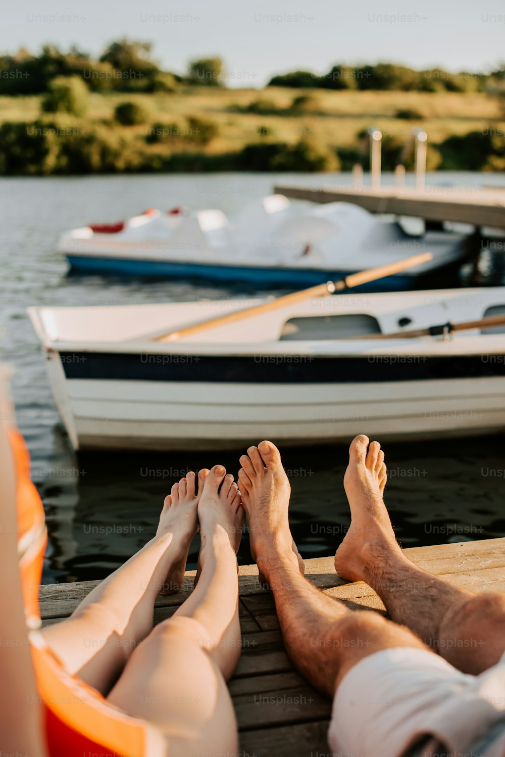 a man and a woman laying on a dock next to a boat