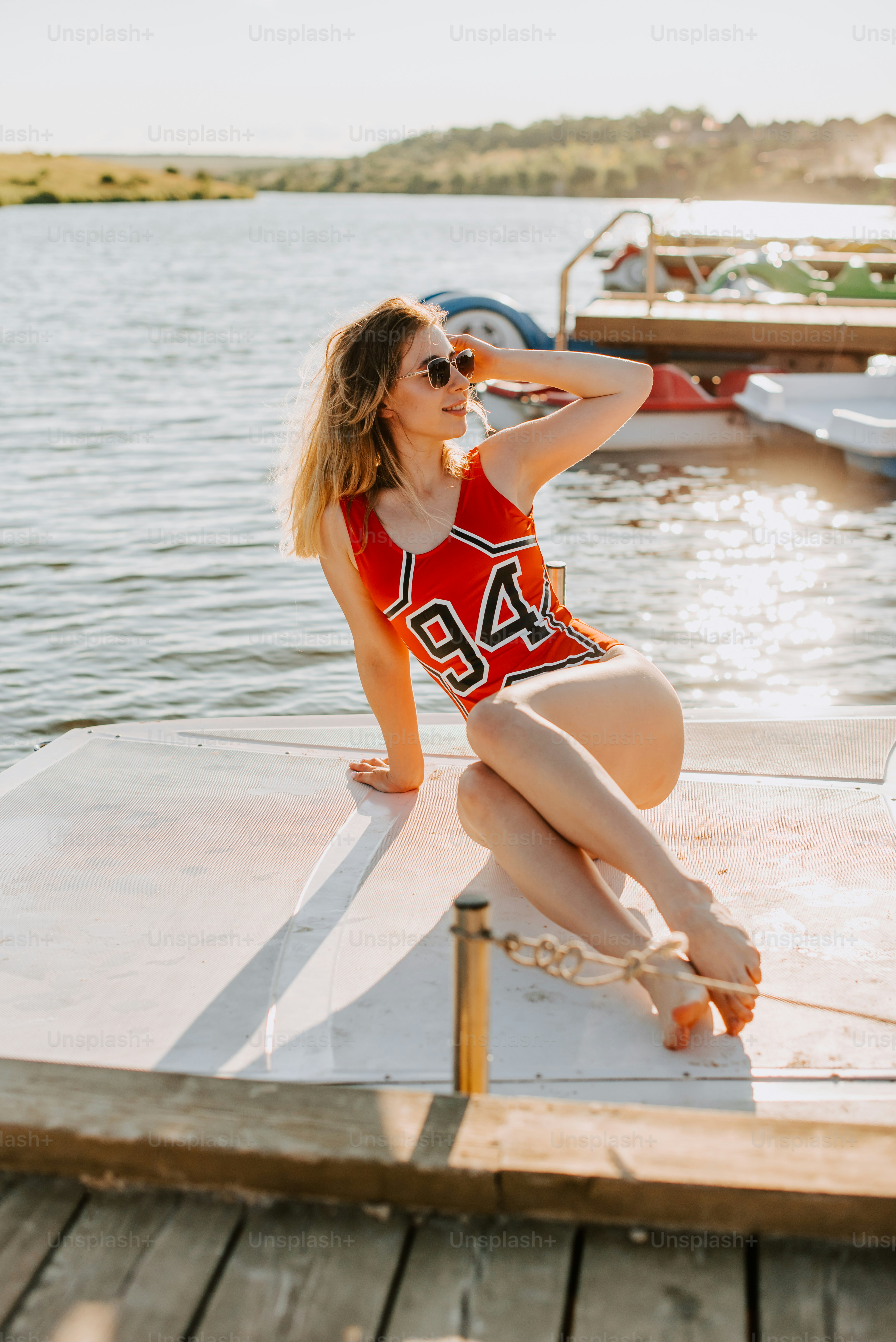 Eine Frau sitzt auf einem Dock und posiert für ein Foto