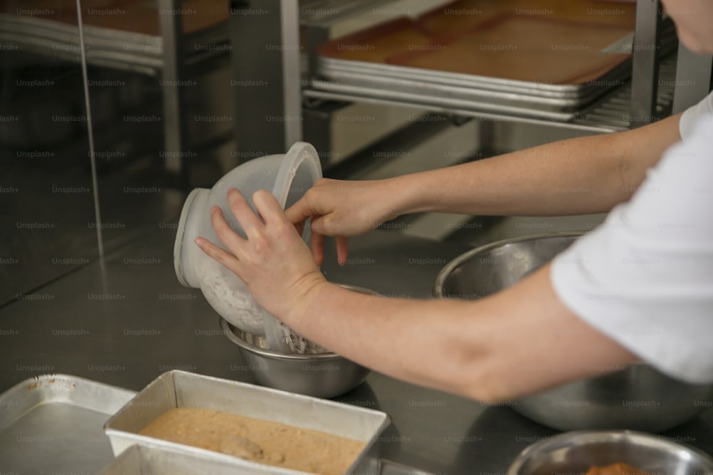 a person in a kitchen putting something in a bowl