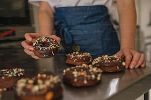a person holding a donut with sprinkles on it