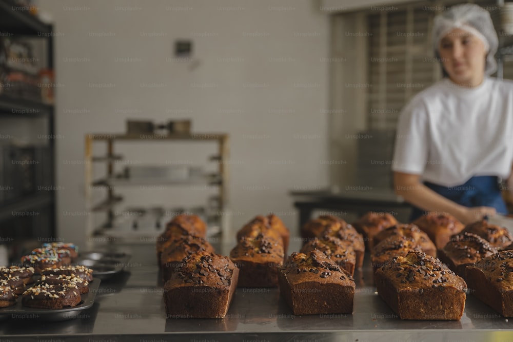 a woman standing behind a counter filled with baked goods