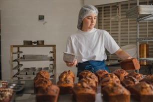 a woman in a white shirt and a bunch of muffins