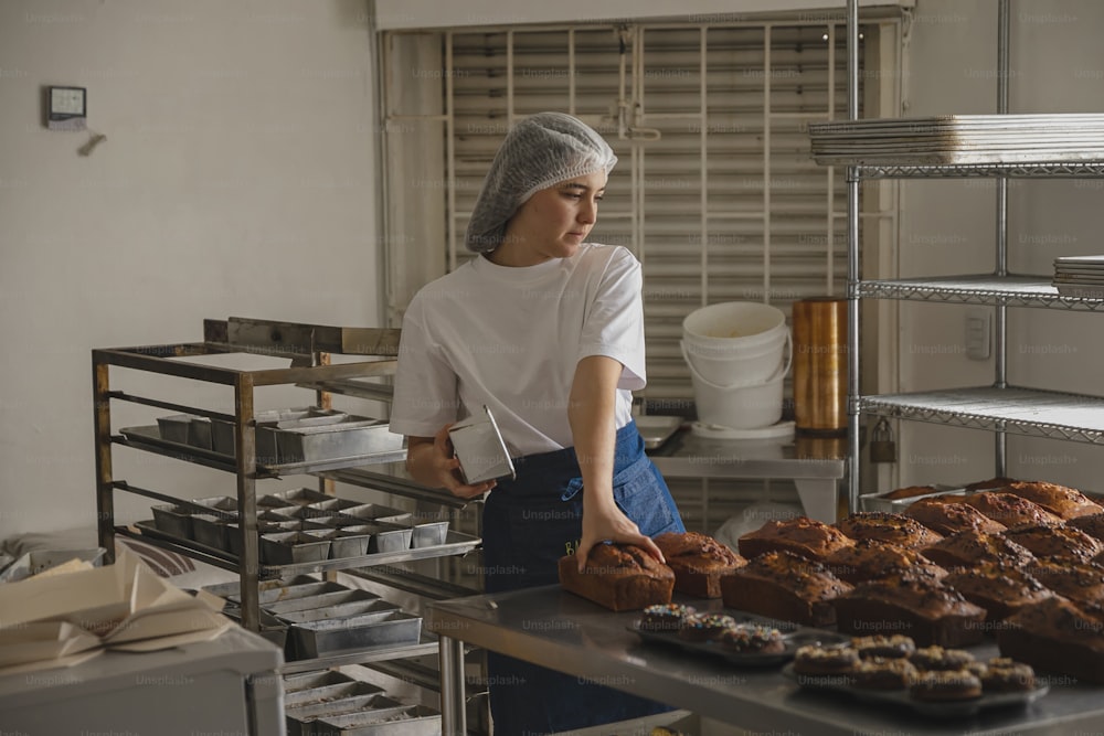 una mujer en una cocina con una bandeja de productos horneados