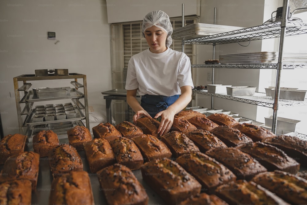 a woman standing in front of a bunch of baked goods