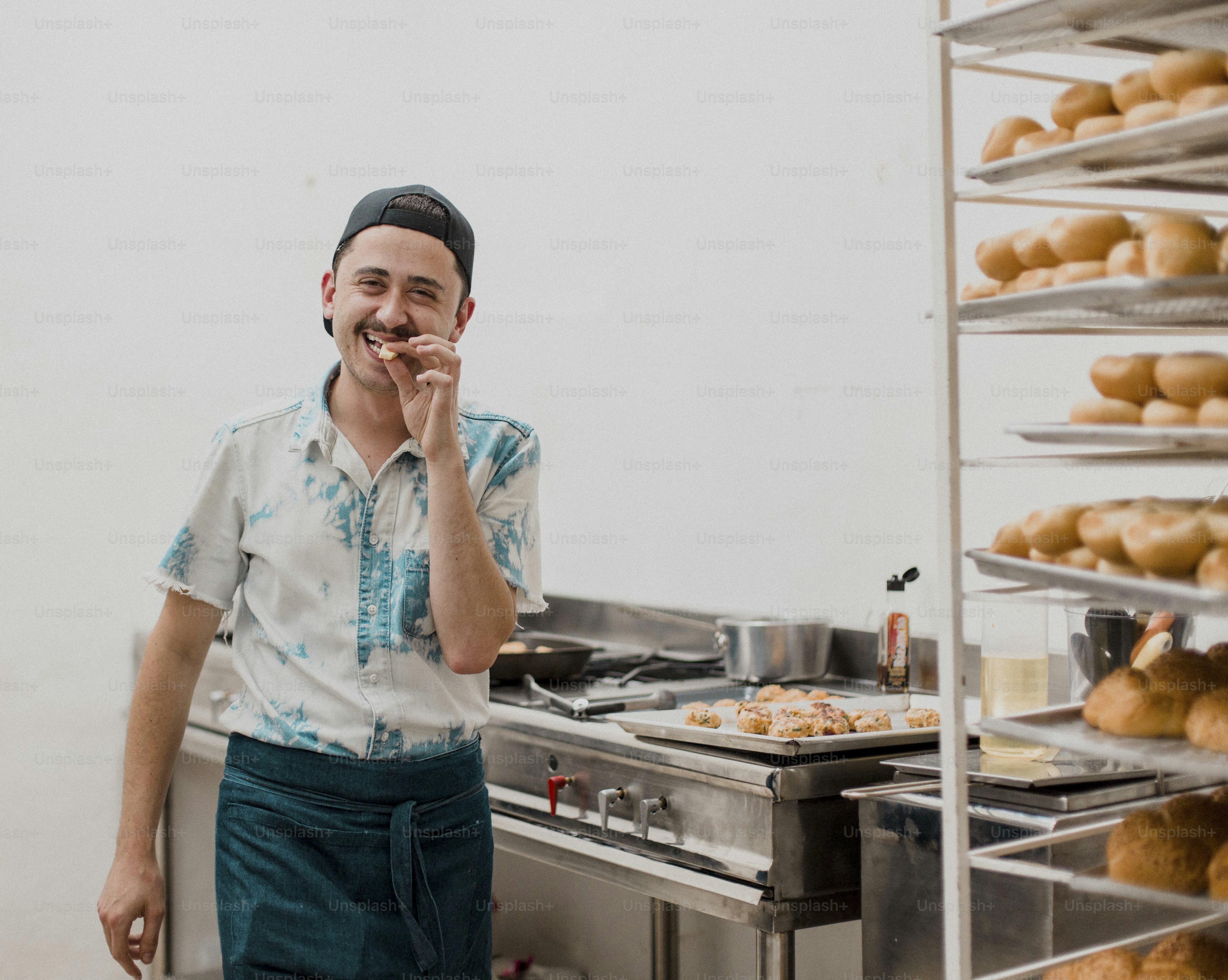 Un hombre parado frente a un montón de rosquillas