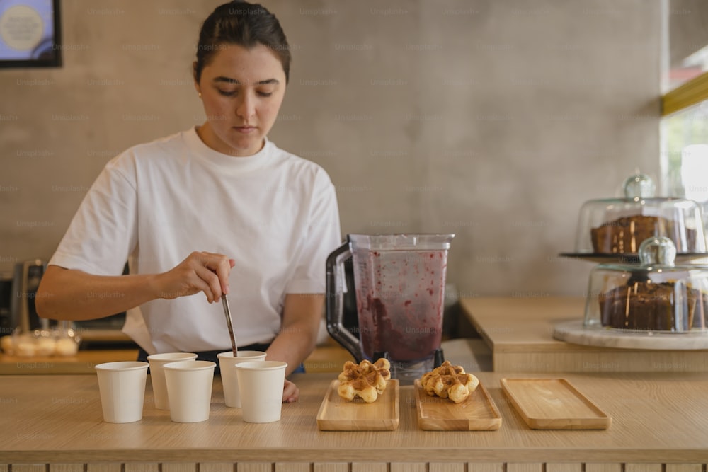 a woman is making a smoothie in a blender