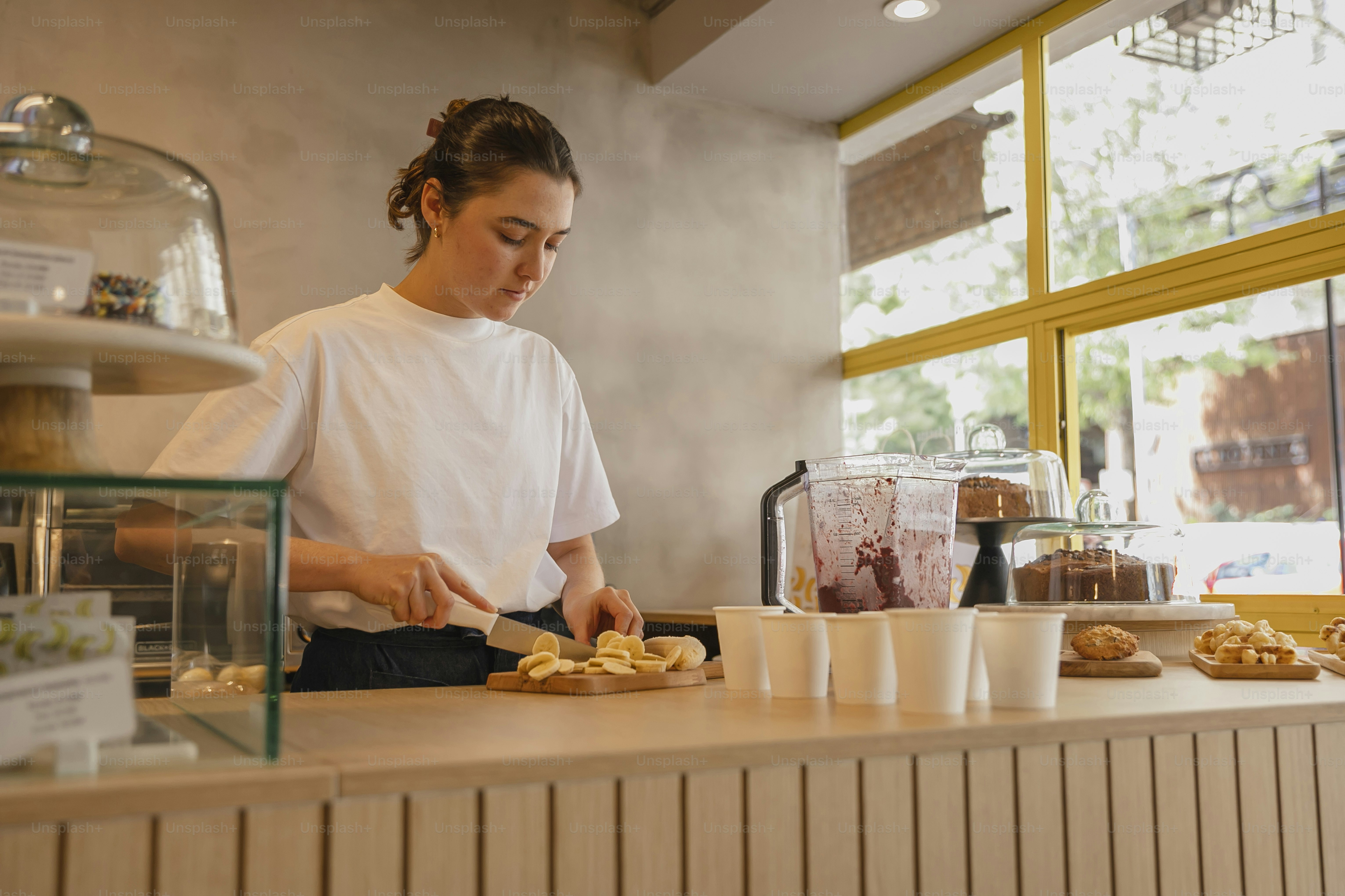 una donna in una camicia bianca che prepara il cibo a un bancone