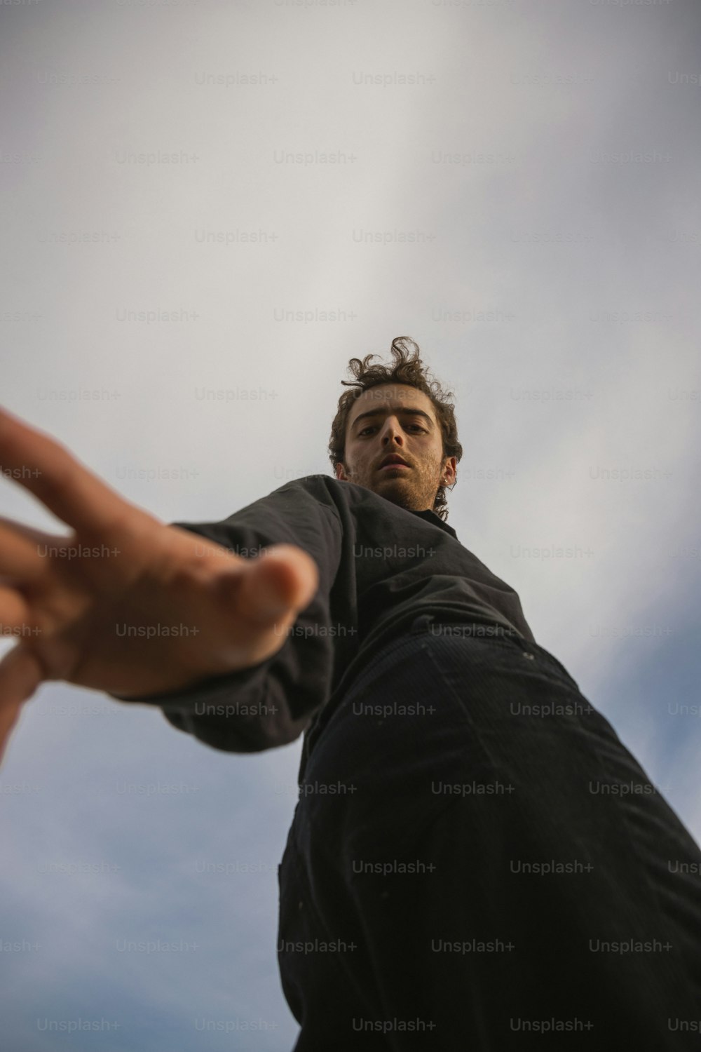 a man holding his hand out to the sky
