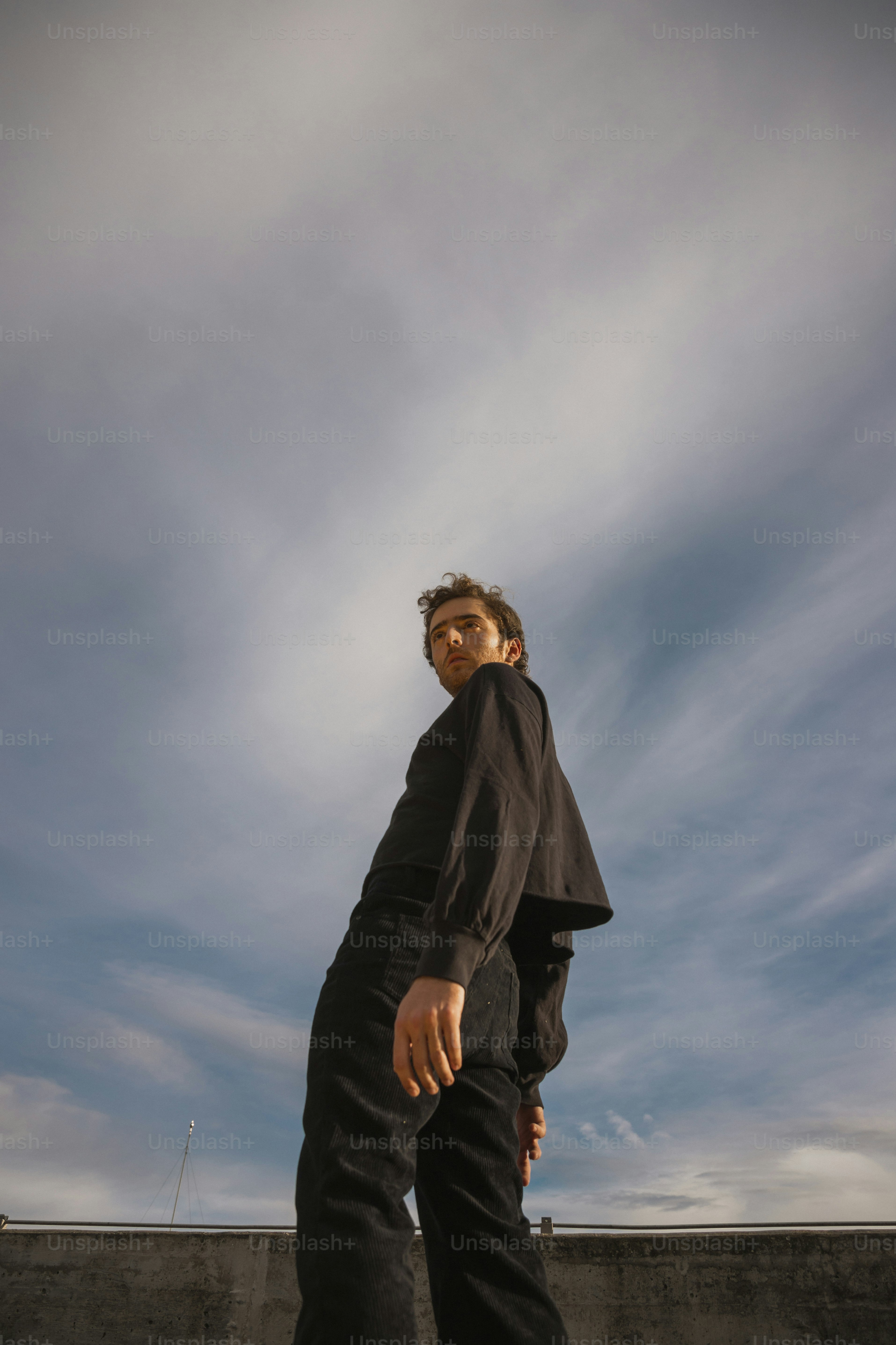 a man riding a skateboard on top of a cement wall