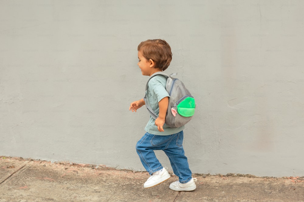 a little boy with a backpack and a frisbee