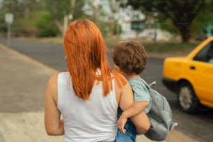 Una mujer que lleva a un niño al otro lado de una calle