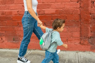 a woman and a child walking down a sidewalk