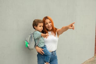 a woman holding a child pointing at something