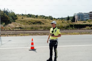 un policier debout à côté d’un cône de circulation