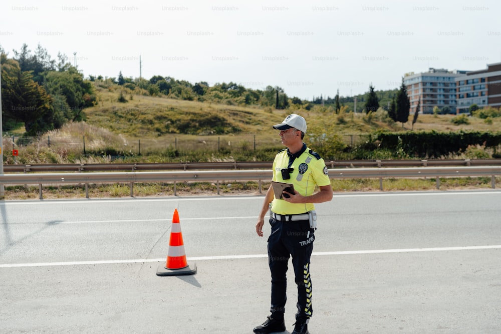 um policial parado ao lado de um cone de trânsito