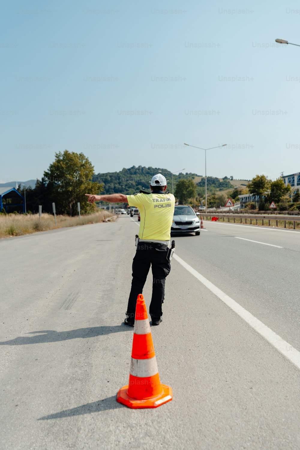 un oficial de policía dirigiendo el tráfico al costado de la carretera
