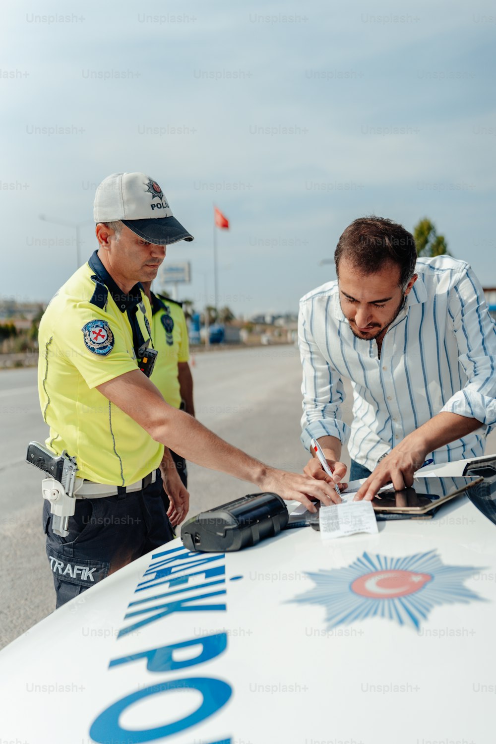 Un hombre firmando una multa para un oficial de policía