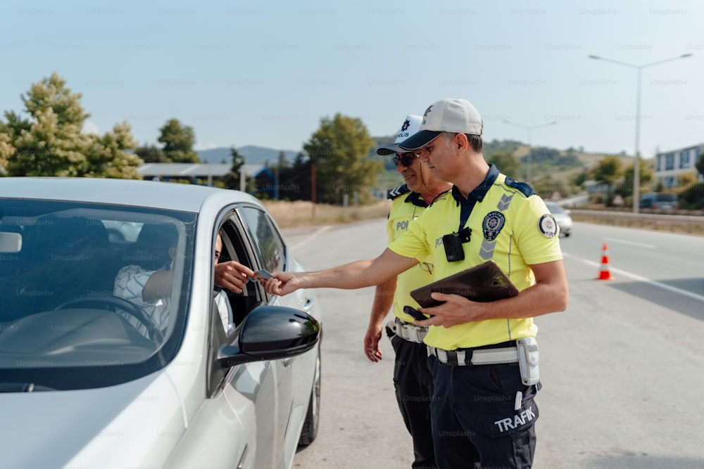 a man in a police uniform standing next to a car