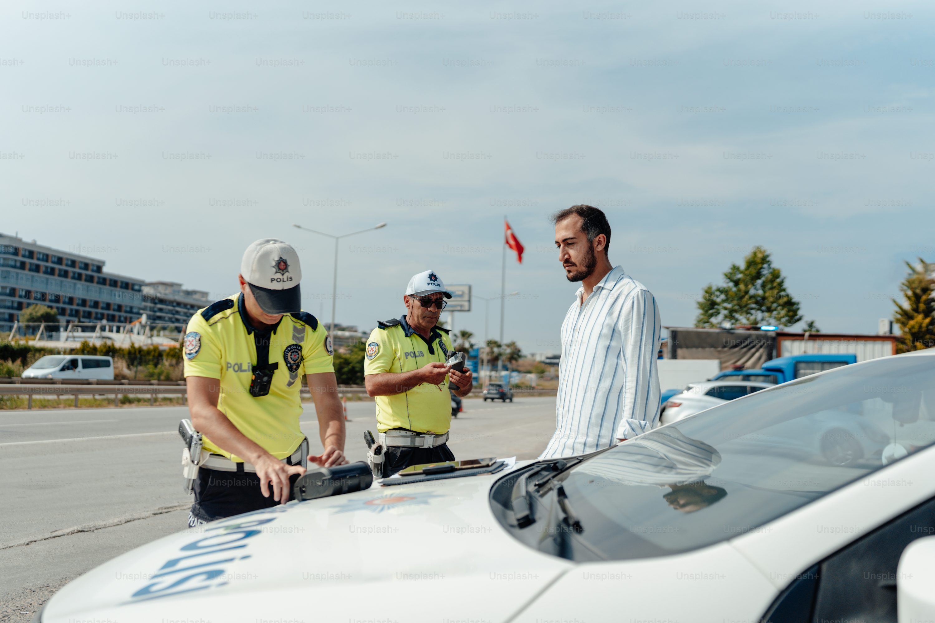 two police officers standing next to a police car