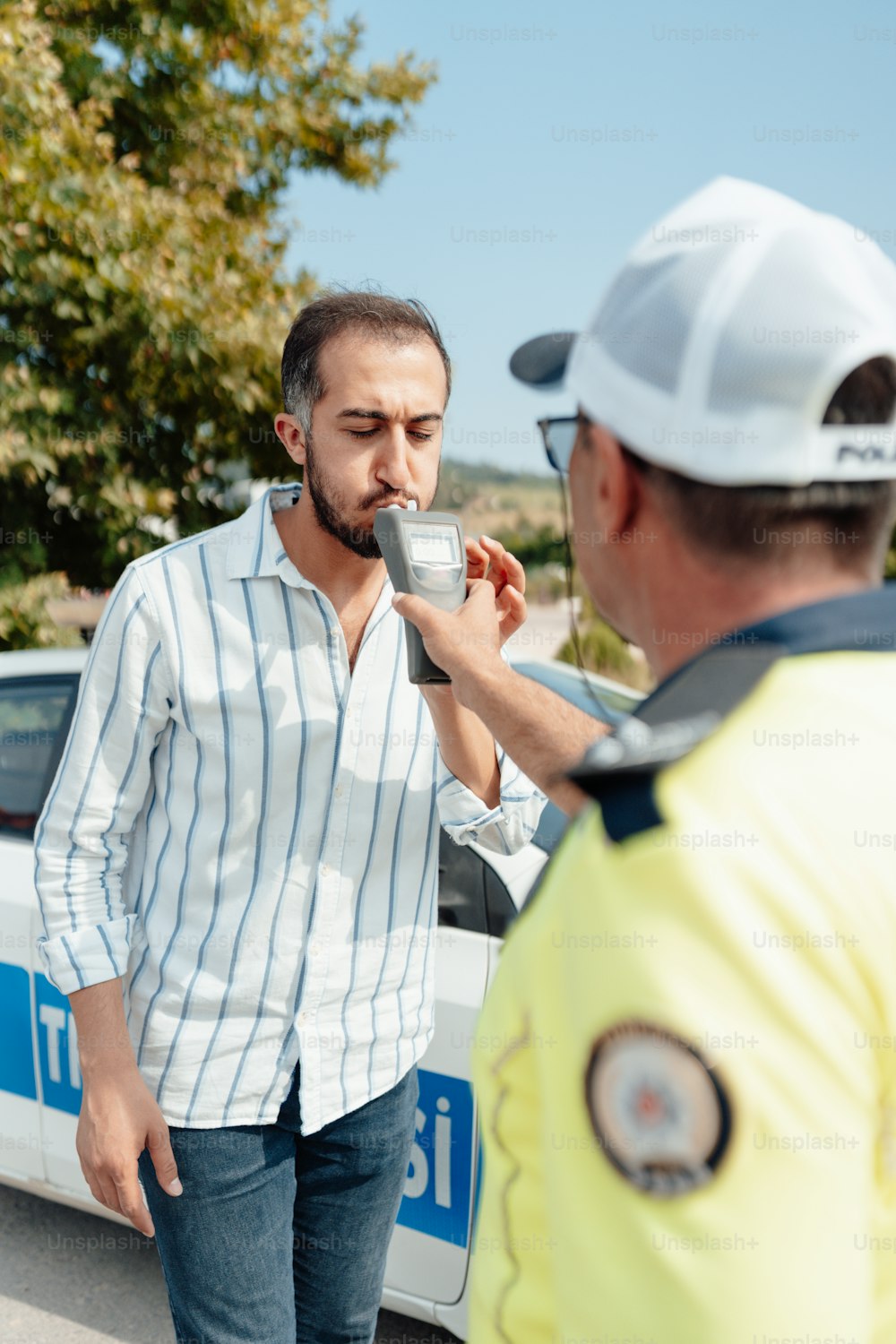 a man drinking from a cup while standing next to another man