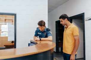 two men standing at a counter in an office